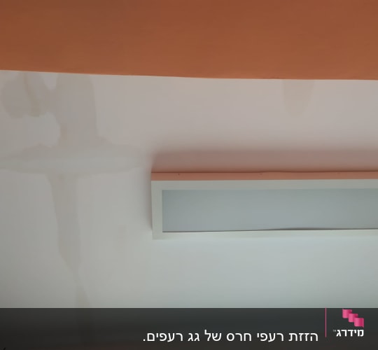 כתם רטיבות על תקרה לבנה עם מדף